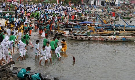 Ratusan warga memunguti sampah plastik yang berserakkan di pinggir Pantai Kenjeran, Surabaya, Jawa Timur