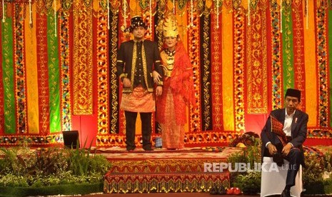 Presiden Joko Widodo (kanan) mengenakan sepatunya saat resepsi ngunduh mantu pernikahan putri dan menantunya Kahiyang Ayu-Bobby Afif Nasution di Medan, Sumatera Utara, Sabtu (25/11).