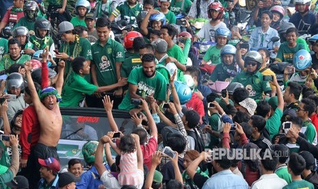 Sejumlah suporter Persebaya mengelukan pemain Persebaya saat diarak, di Surabaya, Jawa Timur, Rabu (29/11).