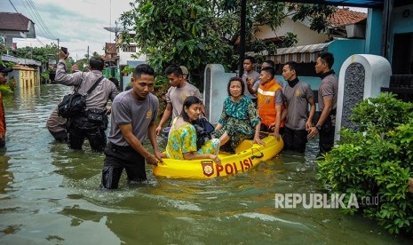 Petugas gabungan mengevakuasi warga terdampak banjir di Kecamatan Pekalongan Utara, Jawa Tengah, Jumat (1/12). 