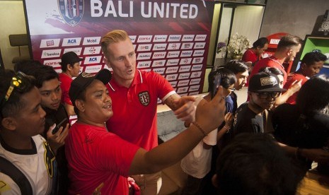 Pemain baru Bali United, Nick Van Der Velden (tengah) berfoto dengan para pendukung klub sepak bola itu seusai perkenalan pemain baru di Denpasar, Kamis (14/12).