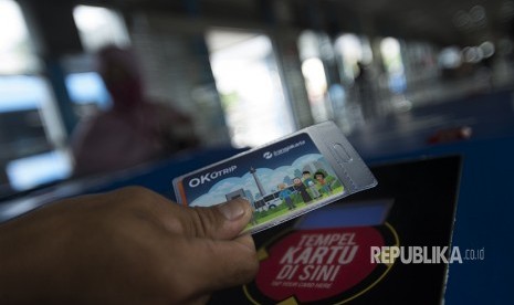 Warga menggunakan kartu One Karcis One Trip (OK Otrip) di hari pertama ujicoba sistem untuk program OK Otrip di halte transjakarta Harmoni, Jakarta, Jumat (22/12).