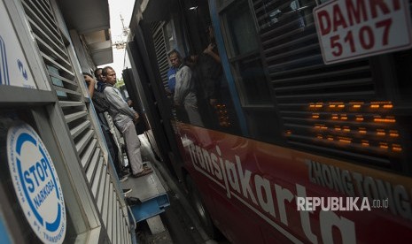 Warga menunggu moda angkutan transjakarta di hari pertama ujicoba sistem untuk program OK Otrip di halte transjakarta Harmoni, Jakarta, Jumat (22/12).