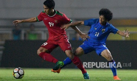  Pemain Timnas Indonesia U-23 Hanif Sjahbandi (kiri) menggiring bola dibayangi pemain Timnas Thailand U-23 Tanasith Siripala dalam pertandingan uji coba di Stadion Pakansari, Cibinong, Bogor, Jawa Barat, Ahad (3/6) malam.