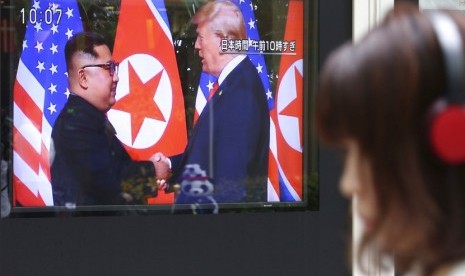 Seorang pria menonton layar TV yang menyiarkan pertemuan  Presiden AS Donald Trump dengan pemimpin Korea Utara Kim Jong Un di Seoul Railway Station di Seoul, Korea Selatan, Selasa (12/6).