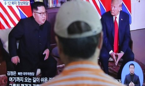  Seorang pria menonton layar TV yang menyiarkan pertemuan  Presiden AS Donald Trump dengan pemimpin Korea Utara Kim Jong Un di Seoul Railway Station di Seoul, Korea Selatan, Selasa (12/6).