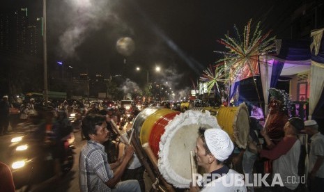 Umat muslim memukul beduk saat malam takbiran di Jalan K.H. Mas Mansyur, Tanah Abang, Jakarta, Kamis (14/6).