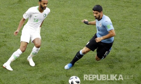    Luis Suarez berebut bola dengan pesepak bola Arab Saudi Abdullah Otayf pada pertandingan grup A Piala Dunia 2018 di Rostov Arena, Rostov na Donu, Rabu (20/6). 