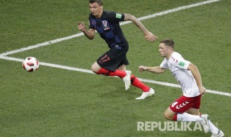  Pemain timnas Denmark Henrik Dalsgaard (kanan) berebut bola dengan pemain Kroasia Mario Mandzukic pada pertandingan babak 16 besar Piala Dunia 2018 antara Denmark melawan Kroasia di Stadion Nizhny Novgorod, Senin (2/7) dini hari WIB.