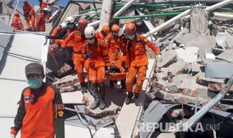  Tim SAR melakukan evakuasi korban gempa yang tertimbun reruntuhan bangunan hotel Roa-Roa di Palu, Ahad (30/9).