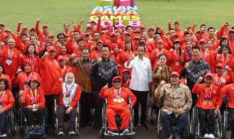 Presiden Joko Widodo (keempat kanan) didampingi Menko PMK Puan Maharani (ketiga kanan), Menpora Imam Nahrawi (kelima kanan), Ketua INAPGOC Raja Sapta Oktohari (kedua kanan) dan Direktur Utama BRI Suprajarto (keenam kanan) berfoto bersama atlet Asian Para Games 2018 saat silaturahmi di Istana Bogor, Jawa Barat, Sabtu (13/10). 