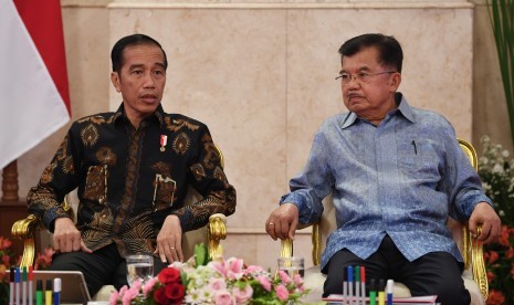 Presiden Joko Widodo (kiri) berbincang dengan Wakil Presiden Jusuf Kalla ketika memimpin sidang kabinet paripurna di Istana Negara, Jakarta, Selasa (16/10/2018). 