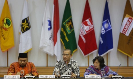 Komisioner KPU Hasyim Asy'ari (tengah) bersama Komisioner Bawaslu Muhammad Afifuddin (kiri) saat melakukan rapat pembahasan penyampaian dan penetapan desain alat peraga kampanye (APG) di Gedung KPU, Jakarta, Senin (29/10/2018). 