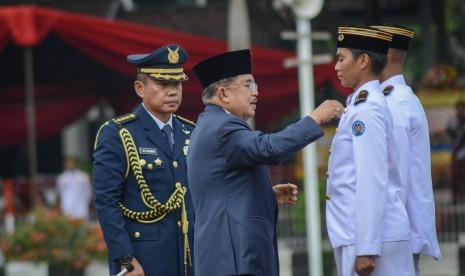 Wakil Presiden Jusuf Kalla (kedua kiri) menyematkan lencana pada perwakilan muda praja saat pelantikan muda praja angkatan XXIX di Kampus Institut Pemerintahan Dalam Negeri (IPDN), Kabupaten Sumedang, Jawa Barat, Jumat (2/11/2018). 