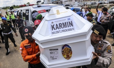 Personel Basarnas dibantu TNI dan Polri memanggul peti jenazah korban jatuhnya pesawat Lion Air JT 610, Karmin, setibanya di terminal cargo Bandara Depati Amir, Pangkalpinang, Kepulauan Bangka Belitung, Jumat (5/11/2018).