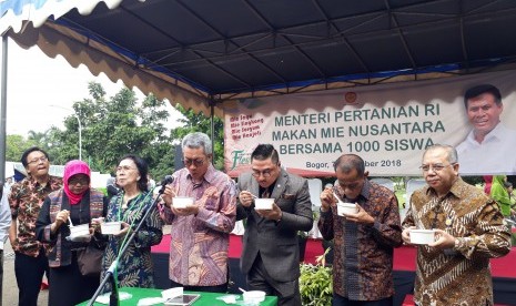 Kepala Balitbangtan Muhammad Syakir, Wakil Ketua Komisi IV DPR RI Michael  Wattimena dan Kepala Badan Ketahanan Pangan Agung Hendriadi (tiga di  tengah) memakan mie non gandum pada acara Pangan Lokal Fiesta di  Auditorium Sadikin  Sumintawikarta, Kampus Pertanian Cimanggu, Bogor, Rabu (7/11).