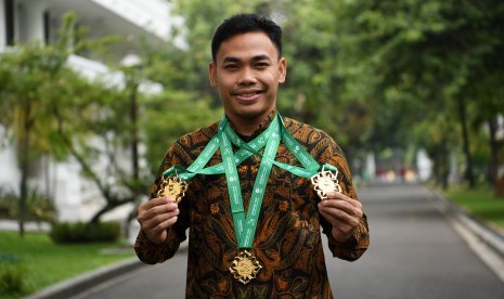 Lifter Eko Yuli Irawan memperlihatkan medali seusai diterima oleh Presiden Joko Widodo di Kompleks Istana Kepresidenan, Jakarta, Kamis (8/11/2018). 