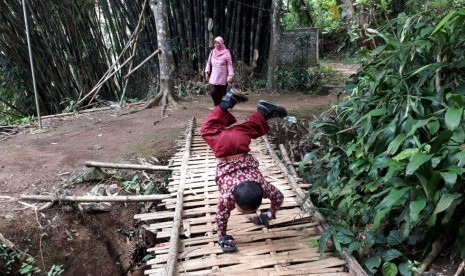 Pelajar Kelas III SDN 10 Cibadak Kabupaten Sukabumi Mukhlis Abdul Kholik (8) berangkat ke sekolah dengan merangkak sejauh tiga kilometer karena kelainan pada bagian kakinya Kamis (8/11).