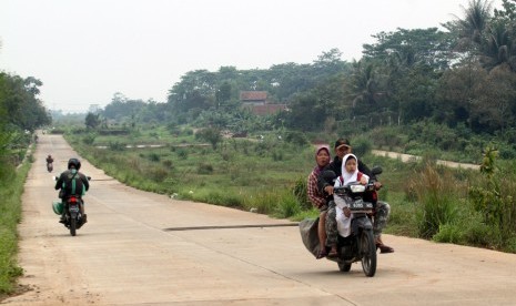 Warga berkendaraan melintas di Proyek pembangunan jalan Bojong Gede-Kemang (Bomang). 