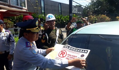 Petugas menindak kendaraan yang diparkir sembarangan di Jalan Riau, Kota Bandung. 