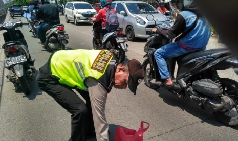 Anggota Polsek Tanjung Duren bersama warga membersihkan ranjau paku di jalan sebelah tol Tomang-Tangerang. Jumat (16/11).