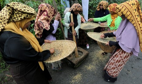 Petani menumbuk dan menampi kopi arabika seusai panen massal dalam rangkaian festival panen kopi gayo di Rembele, Bener Meriah, Aceh, Rabu (21/11/2018).