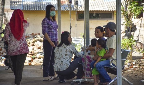 Sejumlah petugas merawat pasien di luar ruangan pasca terjadi gempa bumi di Puskesmas Malaka, Desa Malaka, Kecamatan Pemenang, Lombok Utara, NTB, Kamis (6/12/2018). 