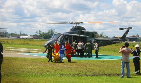 Petugas membawa kantong berisi jenazah korban penembakan di Nduga, di bandara Mozes Kilangin, Timika, Papua, Kamis (6/12/2018).