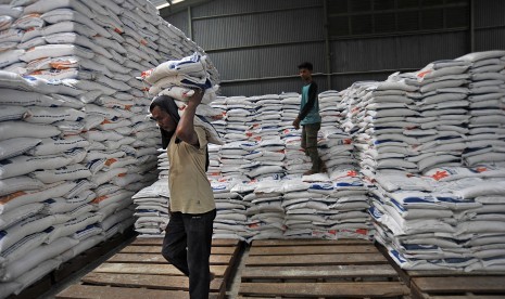 Pekerja mengangkut karung berisi beras dari gudang Perum Bulog untuk dijual ke pasar di Serang, Banten, Sabtu (8/12/2018).