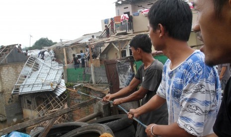 Sejumlah warga bergotong-royong mengevakuasi sisa bangunan rumah terdampak bencana angin puting beliung di Kota Bogor, Jawa Barat, Sabtu (8/12/2018).