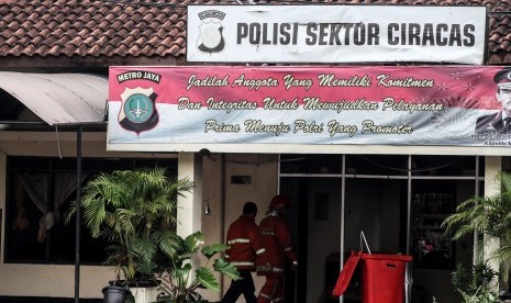 Petugas pemadam kebakaran bergegas seusai memadamkan api yang melanda Polsek Ciracas, Jakarta, Rabu (12/12/2018).