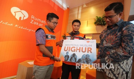 Chief of Program Officer Rumah Zakat, Murni Alit Baginda secara simbolis menyerahkan mockup Aksi Peduli Muslim Uighur kepada relawan saat press Conference pernyataan sikap dan pemberian bantuan Rumah Zakat untuk etnis Uighur, di kantor Rumah Zakat, di Jalan Turangga, Kota Bandung, Jumat (21/12).