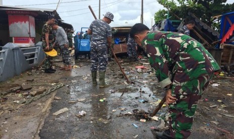 Prajurit TNI AL membersihkan puing-puing di sekitar Pos Pengamatan TNI AL Labuan, Kampung Nelayan I, Desa Teluk, Kecamatan Labuan, Kabupaten Pandeglang, Banten, Senin (24/12). 