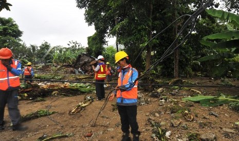 Sejumlah pekerja PT PLN membetulkan kabel jaringan listrik yang terputus akibat dihantam gelombang tsunami di Kawasan Wisata Carita, Pandeglang, Banten, Senin (24/12/2018). 