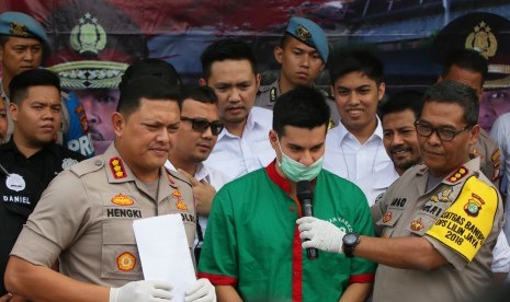 Kabid Humas Polda Metro Jaya Kombes Pol Argo Yuwono (kanan) bersama Kapolres Metro Jakarta Barat, Kombes Pol Hengki Haryadi (kiri) menghadirkan tersangka kasus narkoba Steve Emmanuel (tengah) saat rilis di Polres Metro Jakarta Barat, Kamis (27/12/2018). 