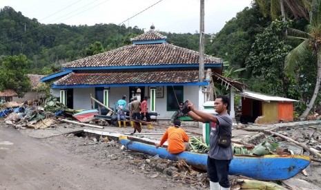 Seorang lelaki sedang berswafoto setelah membersihkan reruntuhan bencana tsunami di Desa Way Muli, Rajabasa, Kabupaten Lampung Selatan