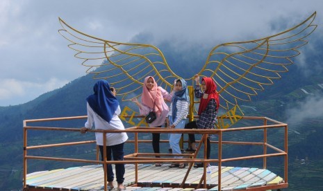 Sejumlah wisatawan berfoto di gardu pandang di kawasan wisata lereng Gunung Merbabu di Gacik, Selo, Boyolali, Jawa Tengah, Kamis (27/12/2018).