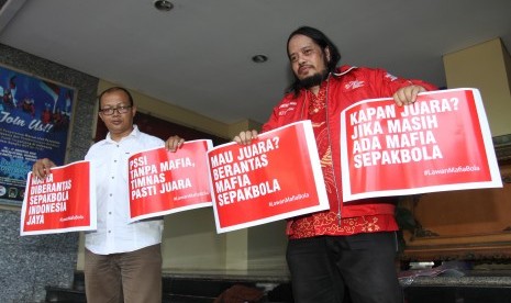 Ketua Umum Paguyuban Suporter Timnas Indonesia (PSTI) Ignasius Indro (kanan) bersama Anggota Paguyuban Suporter Timnas Indonesia (PSTI) Emerson Yuntho (kiri) membawa poster dukungan sebelum beraudiensi dan memberi dukungan Satgas Polri untuk Pemberantasan Mafia Sepak Bola di Krimum, Polda Metrojaya, Jakarta, Jumat (28/12/2018).