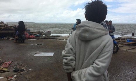 Seorang anak yang selamat dari terjangan tsunami sedang melihat laut. (Ilustrasi)