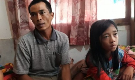 Seorang korban selamat akibat longsor di Desa Sirna Resmi Kecamatan Cisolok Kabupaten Sukabumi Tandi (32) dan anaknya Sindi (8) ditemui di rumah kerabatnya Rabu (2/1). Tandi kehilangan sebanyak 14 anggota keluarga.