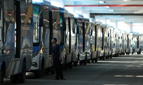 Warga melintas di samping deretan bus Trans Patriot.