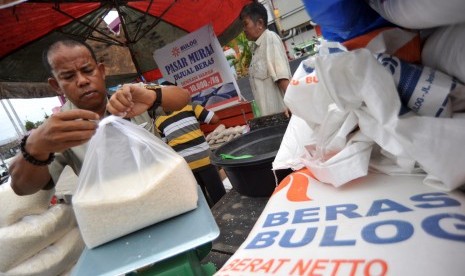 Petugas Bulog mengemas beras saat digelarnya pasar murah di Pasar Raya Padang, Sumatera Barat, Selasa (8/1/2019).