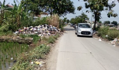 Tumpukan sampah yang berada di tempat pembuangan sampah (TPS) liar masih  terlihat di wilayah Kabupaten Bandung. Tepatnya di Jalan Raya Leuwidulang,  Desa Rancamulya, Kecamatan Pameungpeuk, Kabupaten Bandung, Jumat (11/1).