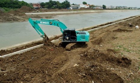 Pekerja mengoperasikan eskavator saat meratakan tanah di sisi tanggul sungai pada proyek normalisasi Sungai Banjir Kanal Timur (BKT) di Semarang, Jawa Tengah, Senin (14/1/2019).