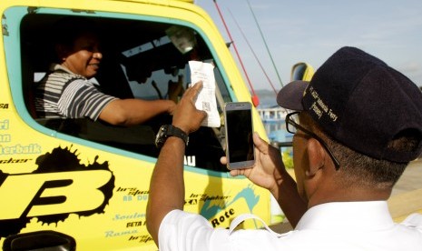 Petugas PT. Angkutan Sungai, Danau dan Penyeberangan (ASDP) Indonesia Ferry, menscan barcode tiket masuk milik seorang pengemudi truk. ASDP menyebut, transaksi pembayaran nontunai memudahkan pengguna jasa.