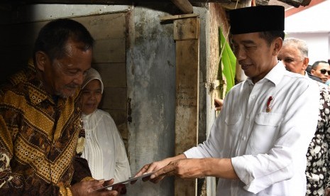 Presiden Joko Widodo (kanan) berbincang dengan penerima fasilitas pemasangan listrik gratis di Kampung Pasar Kolot, Garut, Jawa Barat, Jumat (18/1/2019).