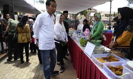 residen Joko Widodo (tengah) didampingi Ibu Negara Iriana Joko Widodo dan Gubernur Jawa Barat Ridwan Kamil meninjau Program Mekaar binaan PNM di Kampung Pasar Kolot, Garut, Jawa Barat, Jumat (18/1/2019). 