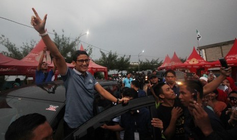 Calon Wakil Presiden nomor urut 02 Sandiaga Salahuddin Uno (kiri) menyapa warga saat berkunjung ke Kampung Nelayan Sukolilo, Surabaya, Jawa Timur, Sabtu (19/1/2019). 