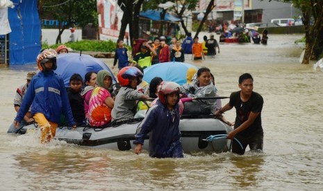 Tim relawan mengevakuasi warga korban banjir di Kelurahan Paccerakkang, Makassar, Sulawesi Selatan, Selasa (22/01/2019). 