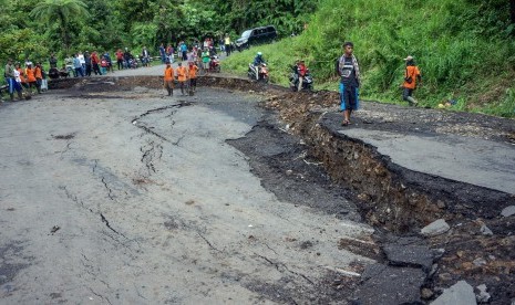 Sejumlah warga melintas di jalan ambles. (Ilustrasi)